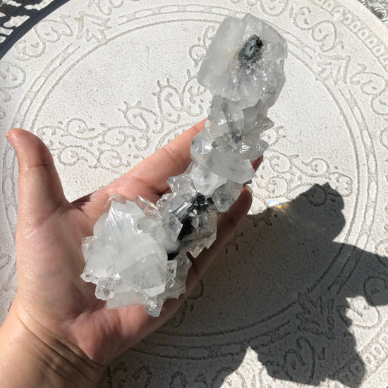 Clear apophyllite in shape of phallus in hand