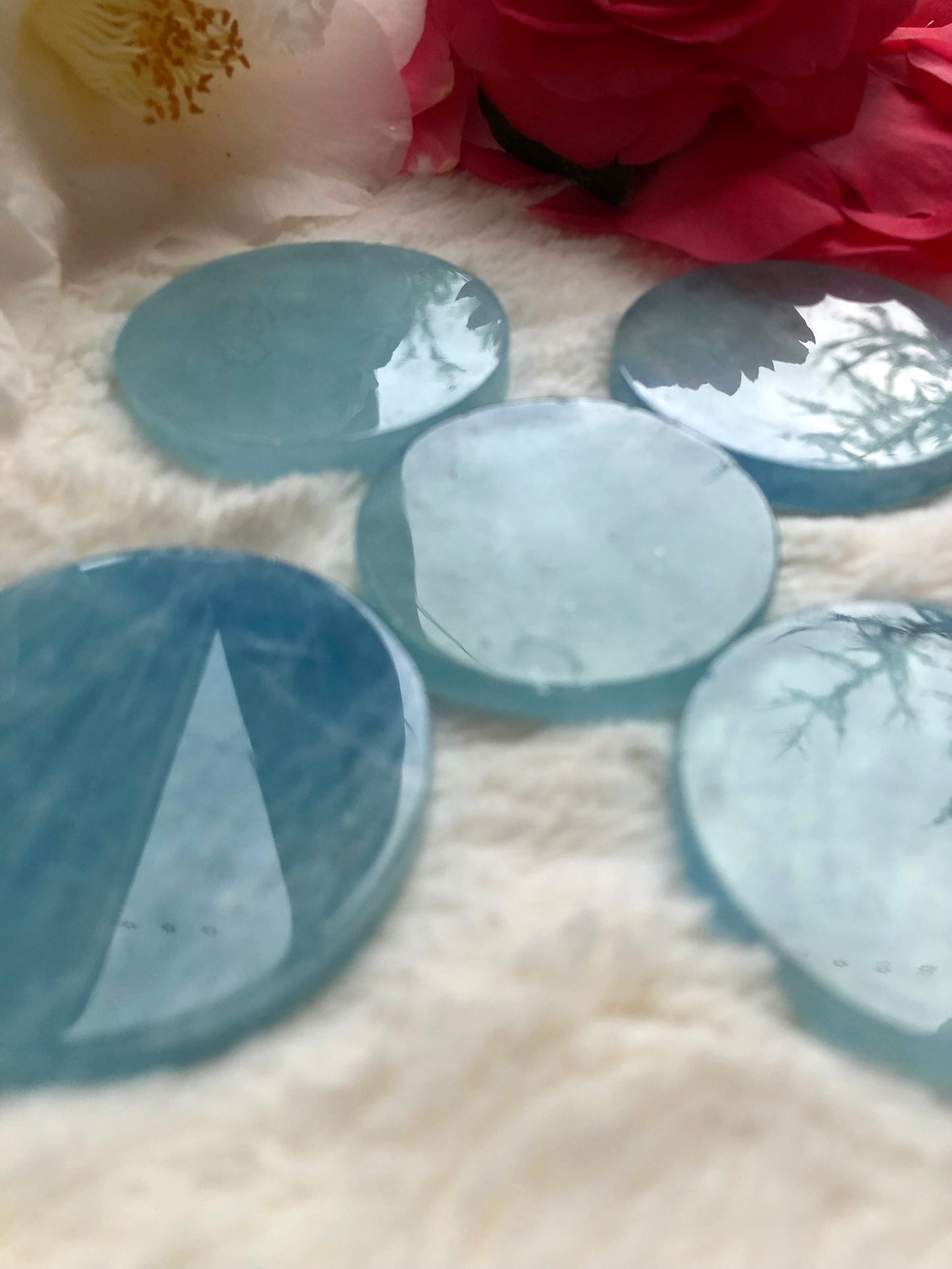 Aquamarine blue disc arranged on white faux fur