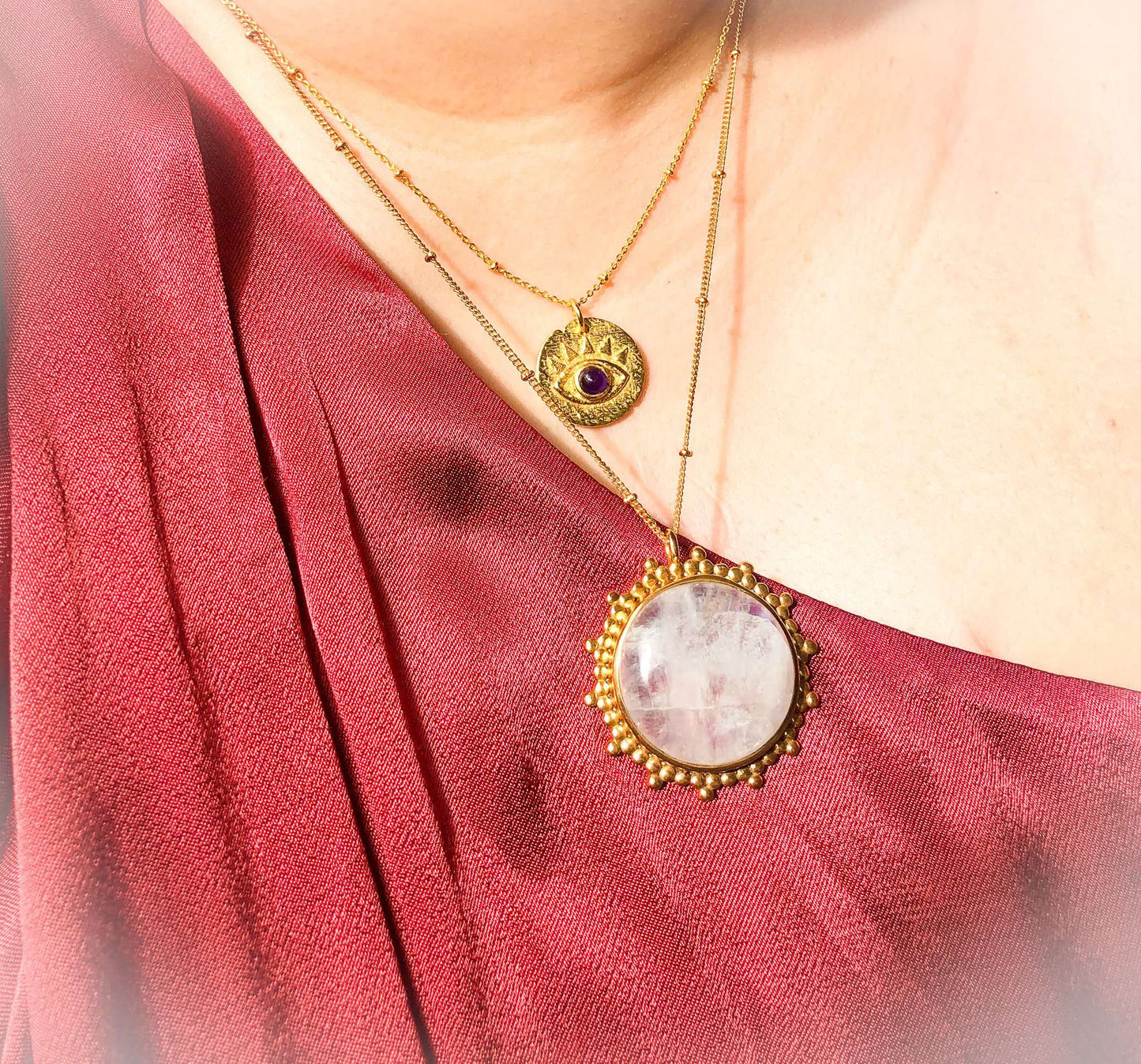 Evil eye pendant gold coloured with amethyst, worn with moonstone pendant on model