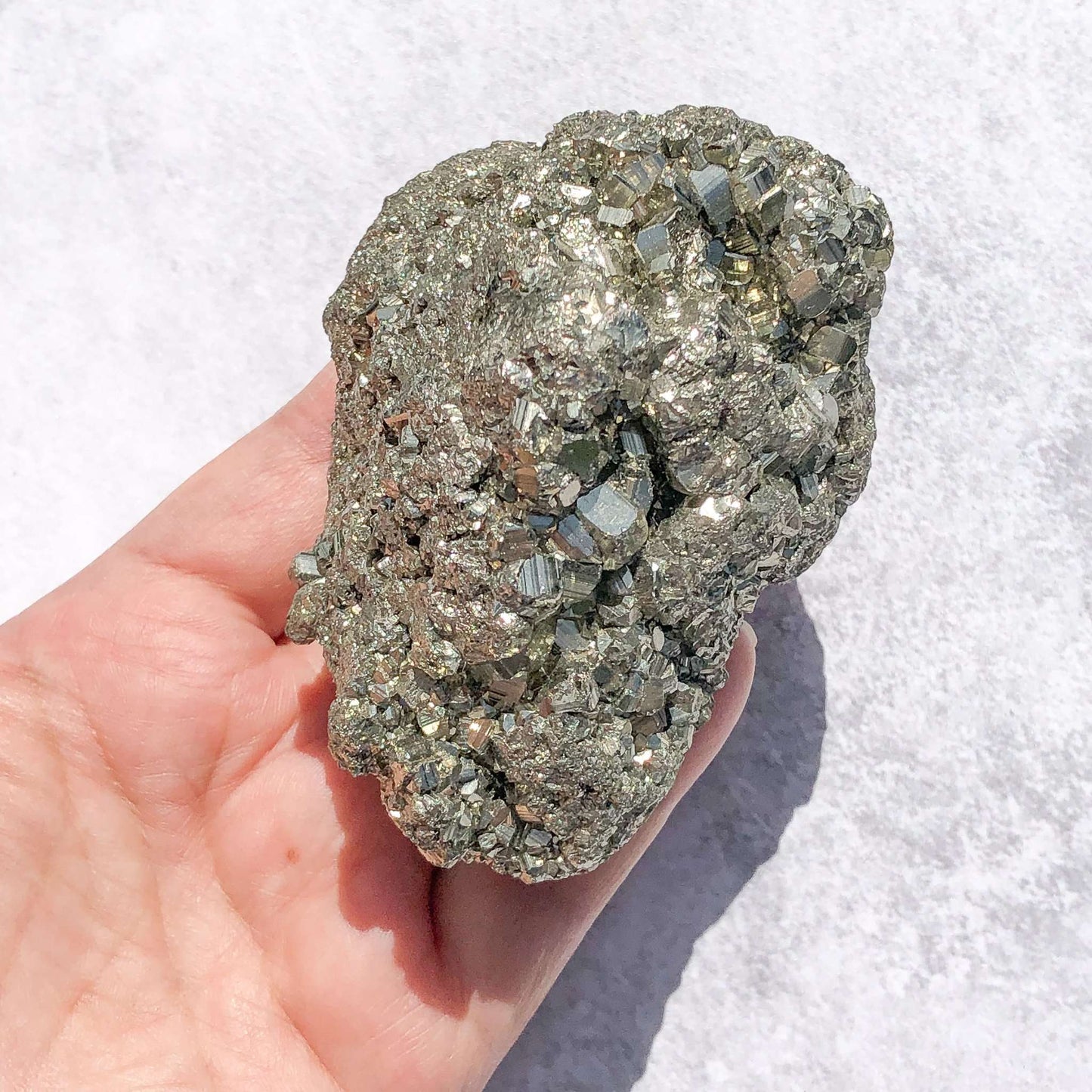 Golden pyrite specimen in hand