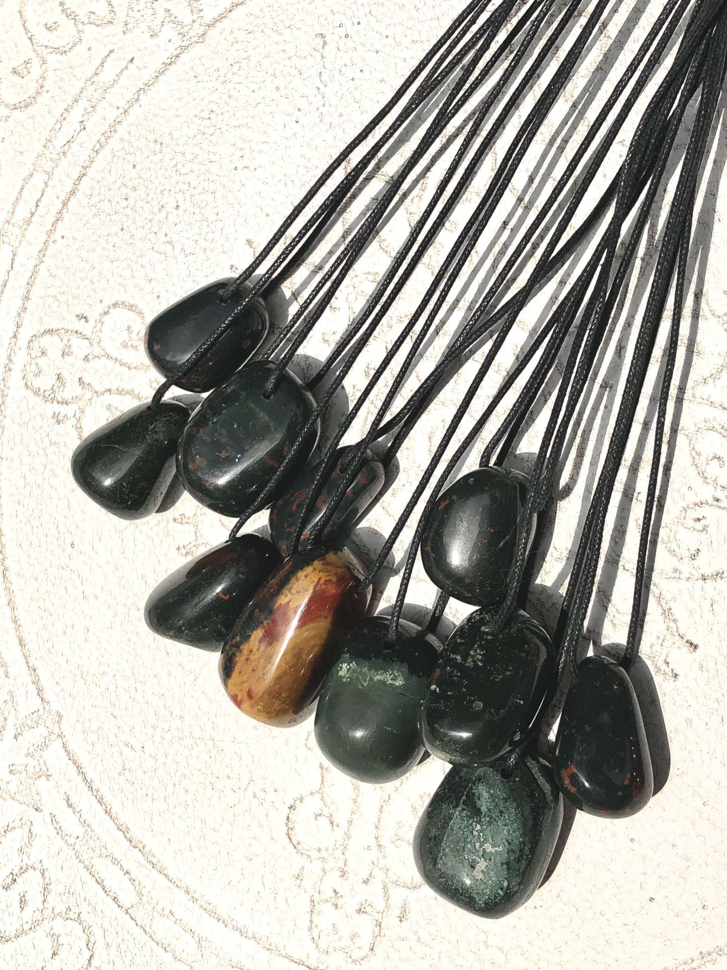Arrangement of bloodstone black cord pendants